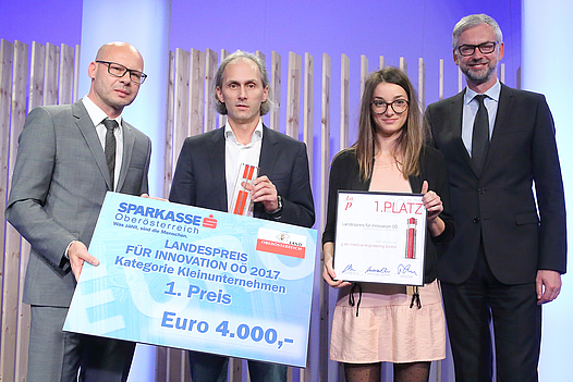 Eine Frau und drei Männer mit Urkunde und Siegerscheck über 4000 Euro in der Kategorie Kleinunternehmen 
