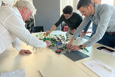 3 Teilnehmer bauen auf einer Plattform mit Lego etwas auf ©Business Upper Austria