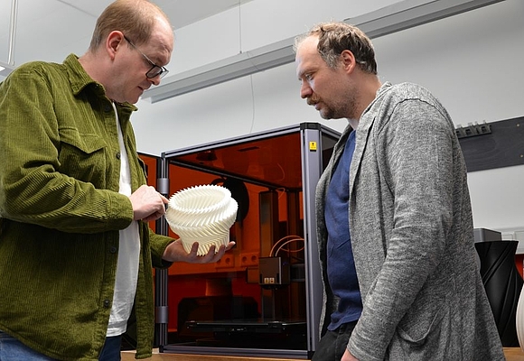 Die Projektmanager Stephan Hölzl und Viktor Weichselbaumer (Building Innovation Cluster) testen den 3D-Drucker. © Business Upper Austria