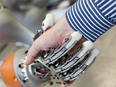 Händeschütteln zwischen einer Roboter- und einer Menschenhand © FH OÖ