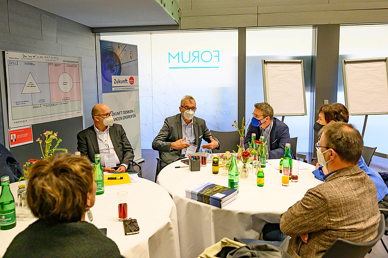 OÖ Zukunftsforum 2022: Workshop-Teilnehmer:innen sitzen an runden Tischen und diskutieren ©cityfoto.at/Pelzl